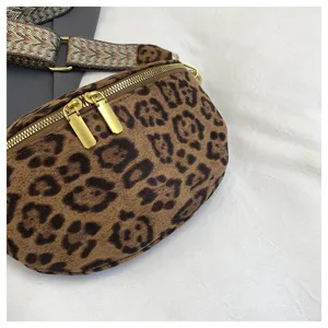 Detail shot of a stylish leopard print fanny pack with a patterned strap and golden zippers.