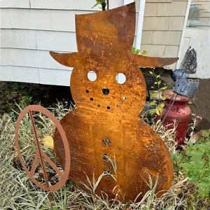 Rusty metal snowman garden stake silhouette for outdoor Christmas holiday yard decoration.