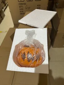 Halloween pumpkin resin ornament detail showing secure styrofoam and plastic packaging protection.