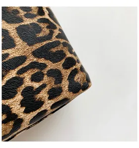 Detail shot of women's shoulder clutch bag featuring classic leopard print and textured leather.