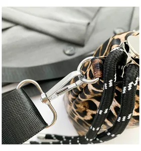 Leopard print handbag detail showcasing metal hardware and black fabric strap construction.