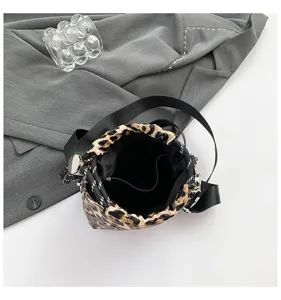 Leopard print drawstring bucket bag detail, featuring black shoulder straps and metal hardware.