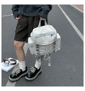 Sac à dos en nylon imperméable de plein air en scène avec poches et sangles réglables.