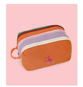 Detailed view of multi-compartment nylon travel cosmetic bag, colorful colorblock design.