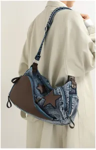 Stylish denim shoulder bag featuring brown leather panels and star patches for women.