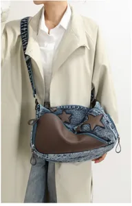Close-up detail of the stylish denim shoulder bag featuring unique brown leather and stars.
