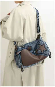 Stylish denim crossbody bag for women with star patches and brown leather contrast trim.