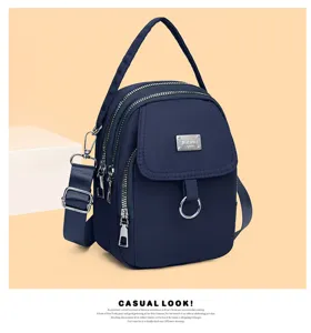 Close-up detail of stylish casual mini crossbody bag crafted in dark blue nylon fabric.