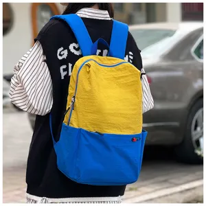 Color-block casual backpack with vibrant yellow and blue, large capacity travel bag.