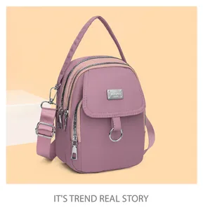 Detail view of the stylish purple women crossbody bag, showcasing multi-zipper pockets and handles.