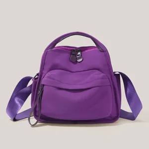 Close-up detail of a purple commuter handbag featuring durable fabric and sleek dual zippers.