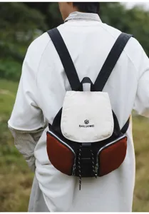 Close-up detail shot of the stylish color-blocked backpack, highlighting its unique flap.