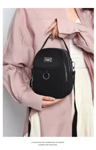 Detail view of stylish black nylon mini backpack, versatile casual crossbody bag.