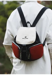 Stylish color-block canvas backpack with dual front pockets and secure flap closure for daily use.