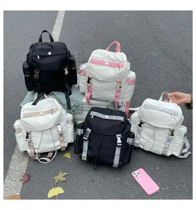 Vue de détail montrant plusieurs sacs à dos décontractés en nylon coloré sur l'asphalte.