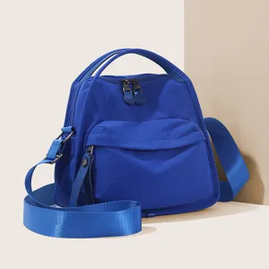 Blue nylon crossbody bag, casual shoulder handbag with top handle and spacious compartments.