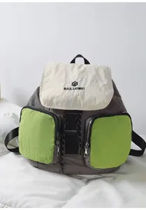 Casual multi-pocket detail of grey and green canvas backpack with cream flap and secure buckle.