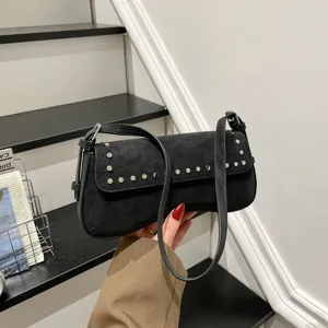 Detailed view of black retro underarm shoulder bag with metal studs and chic commuter style.
