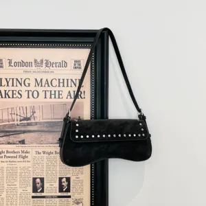Detailed view of black vintage underarm shoulder bag with chic metallic stud embellishments.
