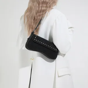 Black suede underarm shoulder bag with metal rivet details, stylish commuter accessory.