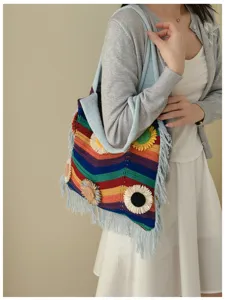 Bolso de hombro de punto a rayas de colores con aplicaciones de flores y flechos de playa.