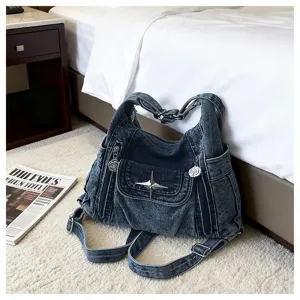 Denim multi-way bag detail, Y2K motorcycle style tote with star and floral charms on carpet.