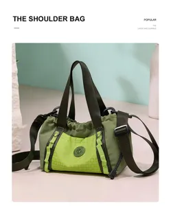 Primo piano della borsa a tracolla verde casual con tasca a rete frontale e spallacci robusti.