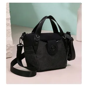 Black nylon crossbody bag with chic plaid pattern front pocket and metal buckle detail.