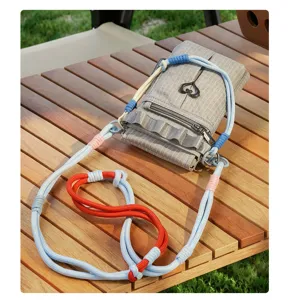 Vue détaillée du sac bandoulière à carreaux tendance avec lanières tressées colorées.