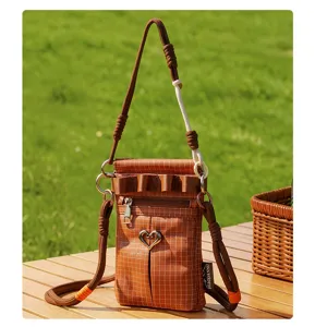 Détail de mini sac bandoulière à carreaux marron, boucle cœur mignonne et lanières pour sport.