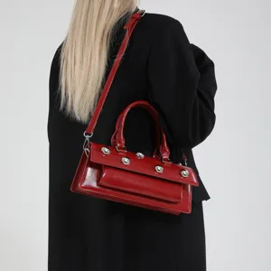 Sac baguette élégant en cuir verni rouge avec des rivets métalliques pour femmes.