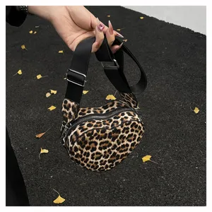 Vue détaillée d'un sac bandoulière léopard en forme de cœur avec sangle noire.