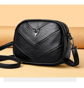 Black leather crossbody shoulder bag for women, chic chevron quilted design with deer head charm.