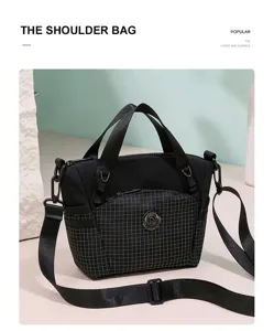 Black plaid shoulder bag with top handles, crossbody strap, front pocket, and durable travel design.