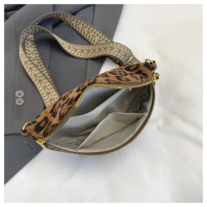 Leopard print crossbody bag detail showcasing interior pockets, wide strap and golden zipper.