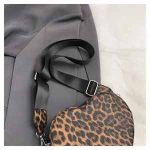 Sac bandoulière chic en forme de cœur imprimé léopard avec sangle noire tendance mode.
