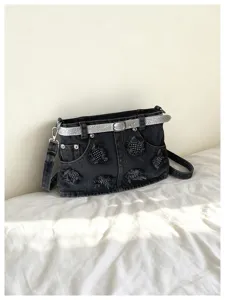 Vista dettagliata della borsa a tracolla in denim nero con cintura glitterata e borchie.
