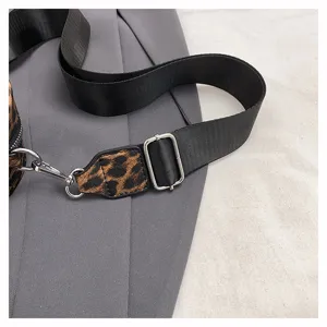 Bandoulière de sac élégante avec motif léopard et nylon noir, pièces métalliques.