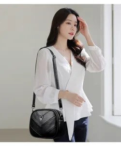 Stylish black leather crossbody bag for women, chic shoulder purse with metal deer decor.