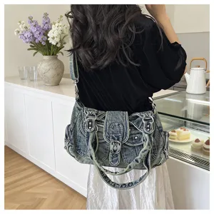 Detailed view of trendy multi-pocket denim shoulder bag, vintage washed finish, casual style.