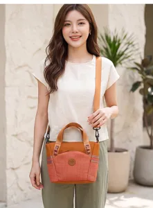 Detailed view of the stylish orange plaid casual shoulder bag with front pocket and strap.