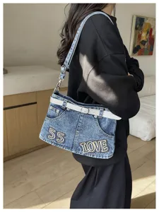Vista dettagliata della borsa a tracolla in denim con design a gonna e cintura brillante.