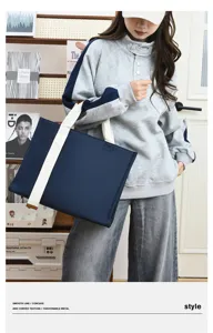 Bolso tote de negocios de tela Oxford azul oscuro en detalle, material duradero con asas blancas.