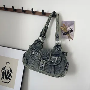 Washed denim shoulder bag for women, trendy multi-pocket cross-body tote with vintage metal accents.