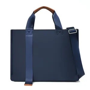 Bolso de negocios impermeable de tela oxford con asas de cuero marrón y correa ajustable.