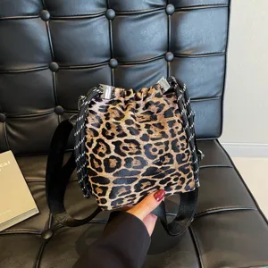 Leopard print bucket bag with drawstring closure and thick black strap, stylish design.