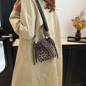 Detailed view of the stylish leopard print bucket bag with black strap and chic drawstring.