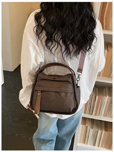 Detail shot of brown grid oxford crossbody bag, featuring spacious capacity and convenient straps.