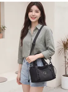 Scopri questa elegante borsa da viaggio nera in tela con tasca a rete e tracolla regolabile.