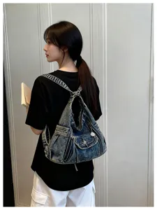 Trendy Y2K denim backpack detail showcasing vintage wash texture, versatile cool bag.